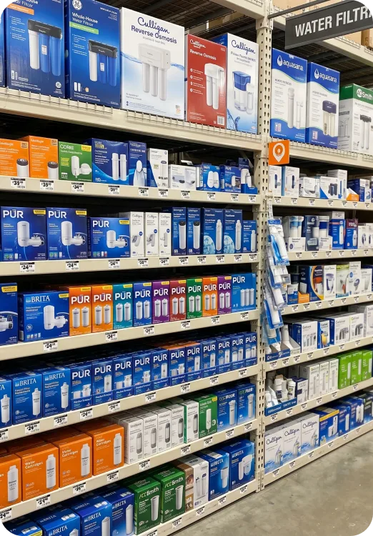 The water filtration aisle in a hardware store, shelves of pitchers, cartridges and tap attachments